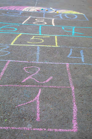 Child jumping classics on the pavement. Selective focus.childの写真素材