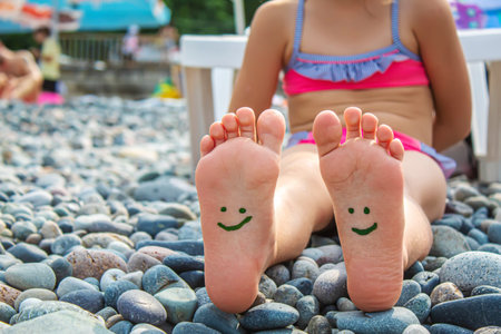 Child feet painted with paints on the sea. Selective focus. Kid.の写真素材