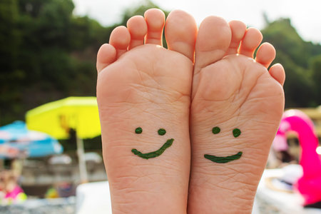 Child feet painted with paints on the sea. Selective focus. Kid.の写真素材