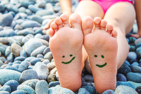 Child feet painted with paints on the sea. Selective focus. Kid.の写真素材