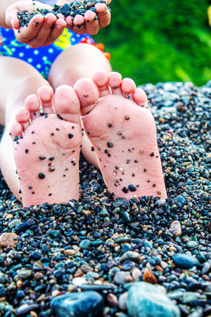Child feet painted with paints on the sea. Selective focus. Kid.の写真素材