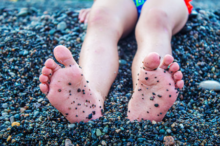 Child feet painted with paints on the sea. Selective focus. Kid.の写真素材