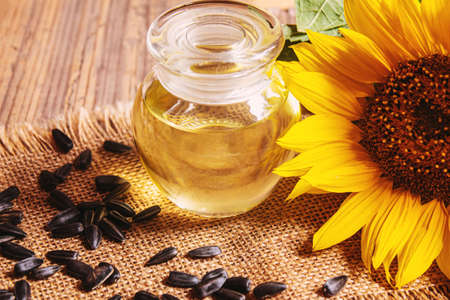 Sunflower seeds and oil bottle on old wooden background. Selective focus.natureの写真素材