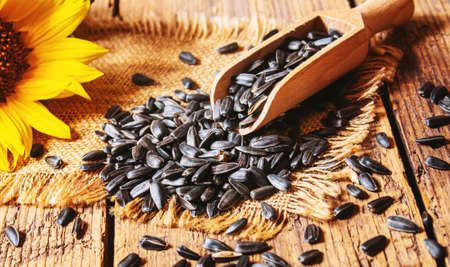 Sunflower seeds and oil bottle on old wooden background. Selective focus.natureの写真素材