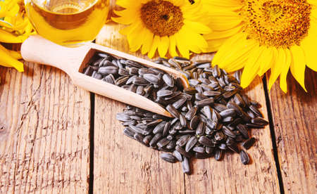 Sunflower seeds and oil bottle on old wooden background. Selective focus.natureの写真素材