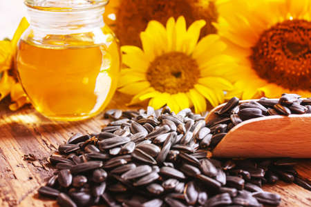 Sunflower seeds and oil bottle on old wooden background. Selective focus.natureの写真素材