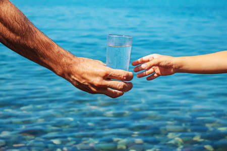 The father gives the child a glass of water. Selective focus.natureの写真素材