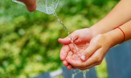 The child washes his hands in the street. selective focus. natureの写真素材