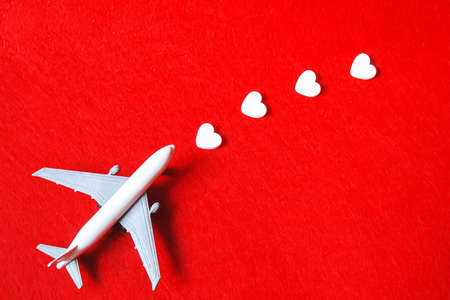 Hearts and a plane on a red background. Valentines Day. Selective focus.