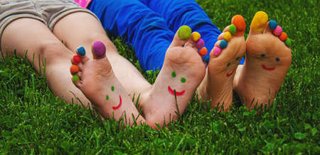 Children's feet with a pattern of paints smile on the green grass. Selective focus..childの写真素材