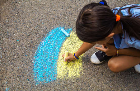 Children draw the Ukrainian flag house on the pavement. selective focus. childの写真素材