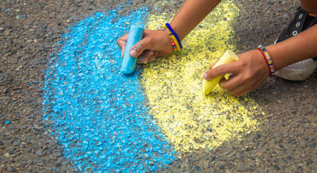 Children draw the Ukrainian flag house on the pavement. selective focus. childの写真素材