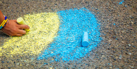Children draw the Ukrainian flag house on the pavement. selective focus. childの写真素材