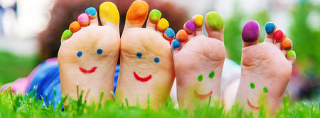 Children's feet with a pattern of paints smile on the green grass. Selective focus.childの写真素材