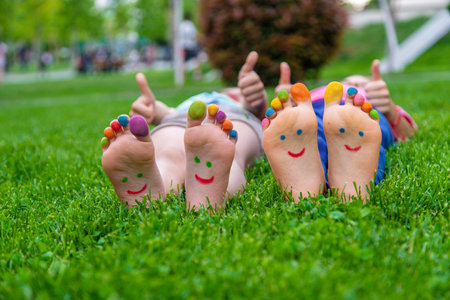 Children's feet with a pattern of paints smile on the green grass. Selective focus.childの写真素材