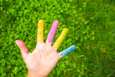 Childrens hands in the colors of summer. Selective focus.