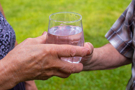 Grandmother gives grandfather water. selective focusの写真素材