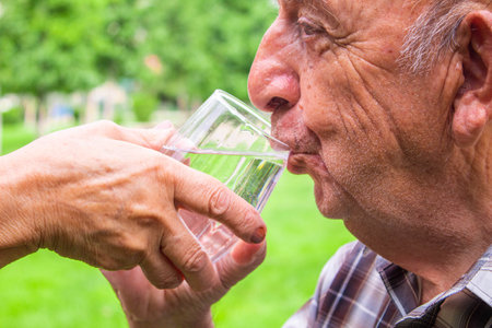 Grandmother gives grandfather water. selective focusの写真素材