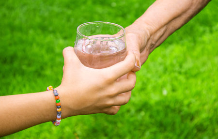 Grandmother giving a glass of clean water to a child. Selective focus. nature.の写真素材