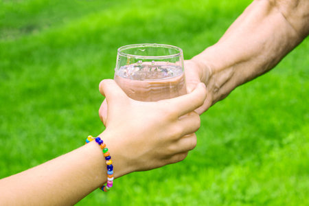 Grandmother giving a glass of clean water to a child. Selective focus. nature.の写真素材