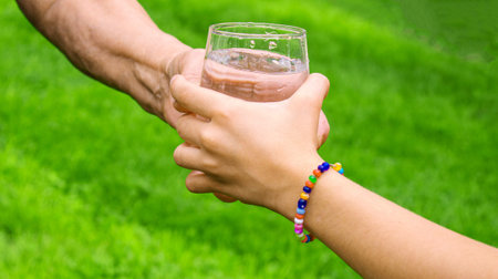 Grandmother giving a glass of clean water to a child. Selective focus. nature.の写真素材