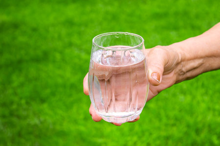 Grandmother giving a glass of clean water to a child. Selective focus. nature.の写真素材