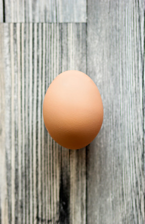One egg on a blue wooden surface