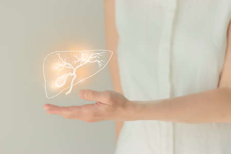 Unrecognizable female patient in white clothes, highlighted handrawn gall bladder in hands. Human digestive system issues concept.の写真素材