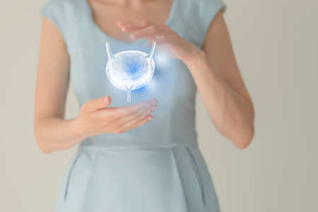 Unrecognizable female patient in blue clothes, highlighted handrawn bladder in hands. Human renal system issues concept.の写真素材
