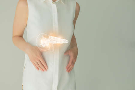 Unrecognizable female patient in white clothes, highlighted handrawn pancreas. Human digestive system issues concept.の写真素材