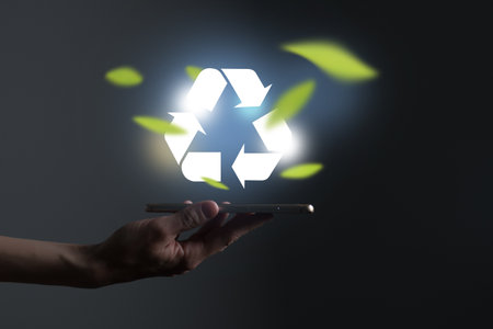 Hand holding recycle symbol on a screen of mobile phone. Mobile applications as asource of information about recycle and sustainability.の写真素材