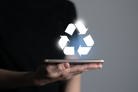 Hand holding recycle symbol on a screen of mobile phone. Mobile applications as asource of information about recycle and sustainability.の写真素材