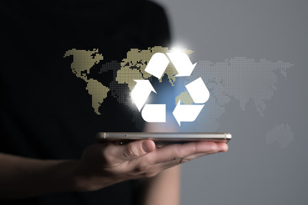 Hand holding recycle symbol on a screen of mobile phone. Mobile applications as asource of information about recycle and sustainability.の写真素材