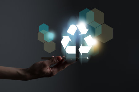 Hand holding recycle symbol on a screen of mobile phone. Mobile applications as asource of information about recycle and sustainability.の写真素材