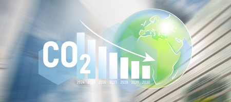 Decreasing bar graph, carbon footprint concept. Motion blur of futuristic cityscape on the background.の写真素材