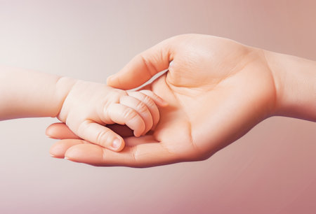 adult female palm lies the small palm of a babyの素材