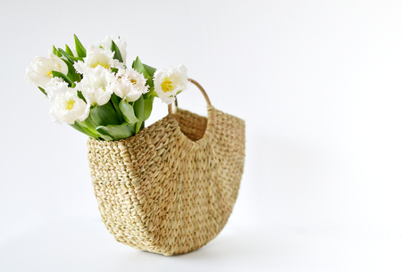 Wicker Handbag with Flowers Tulips, Spring Time, Summer Concept, White Background, Copy Spaceの写真素材
