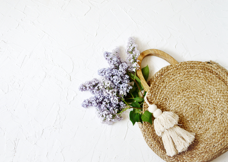 Wicker Handbag with Lilac Flowers, Spring Time, Summer Concept, White Background, Copy Space, Top Viewの写真素材