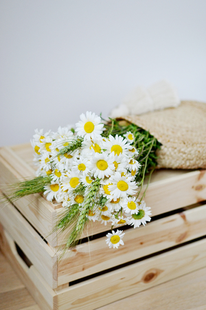 Wicker Handbag with Flowers Chamomile, Wooden Box, Summer Concept, White Background, Copy Space, Modern Design, Eco Scandinavian Styleの写真素材