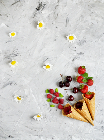 Various Berries in Waffle Cones Summer Tine Minimalism Style Gray Concrete Backgroundの写真素材