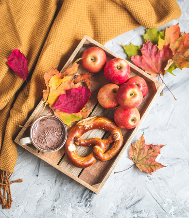 Tea Cup Hot Chocolate Coffee Autumn Time Bakery Pretzel Toned Photo Knitting Scarf Blanket Yellow Leaves Gray Backgroundの写真素材