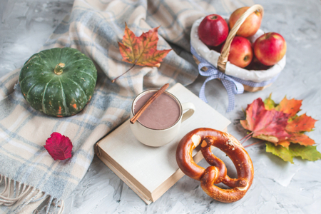 Tea Cup Hot Chocolate Coffee Autumn Time Bakery Pretzel Toned Photo Knitting Scarf Blanket Yellow Leaves Gray Backgroundの写真素材