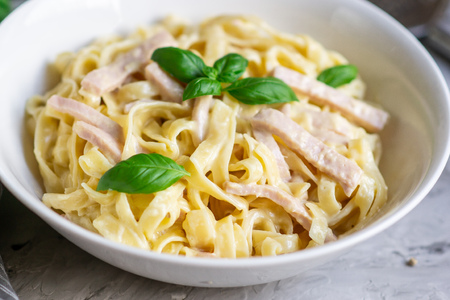 Cooked tagliatelle pasta on a plate with Carbonara sauceの写真素材