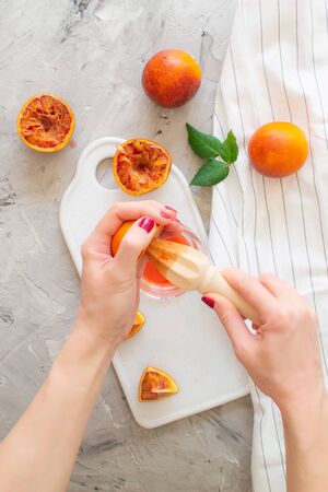 Fresh Red Orange Juice in the Glass Summer Morning Drink Beverage Wooden Hand Juicerの写真素材