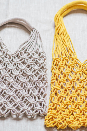 Handmade macrame shopping bags on the linen background, ECO friendly. Embroidery. Modern summer conceptの写真素材