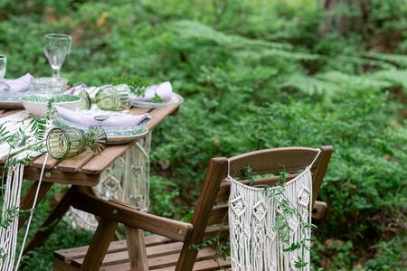 Wedding reception table with macrame tablecloth, decoration on a rustic wooden tableの写真素材