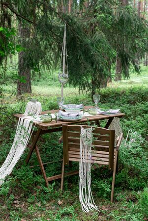 Wedding reception table with macrame tablecloth, decoration on a rustic wooden tableの写真素材