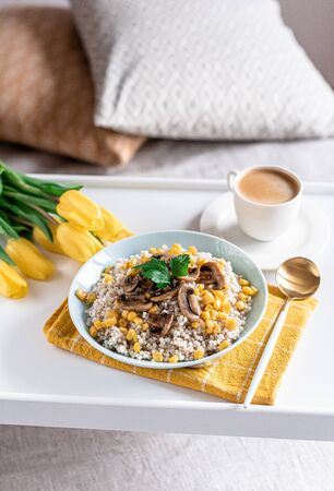 Pearl barley porridge with mushrooms and corn, healthy food concept, breakfast, black coffeeの写真素材