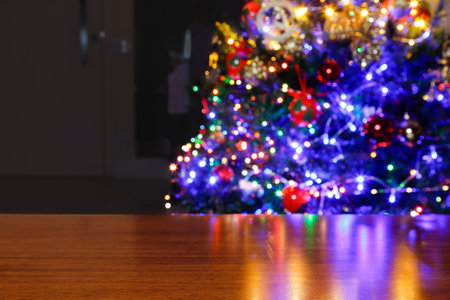 Red, yellow and silver Christmas present. On top of wooden table with background of Christmas trees.の写真素材