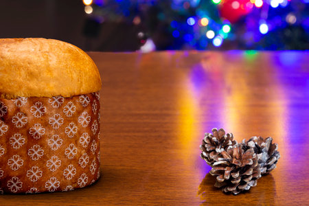 Red, yellow and silver Christmas present. On top of wooden table with background of Christmas trees.の写真素材